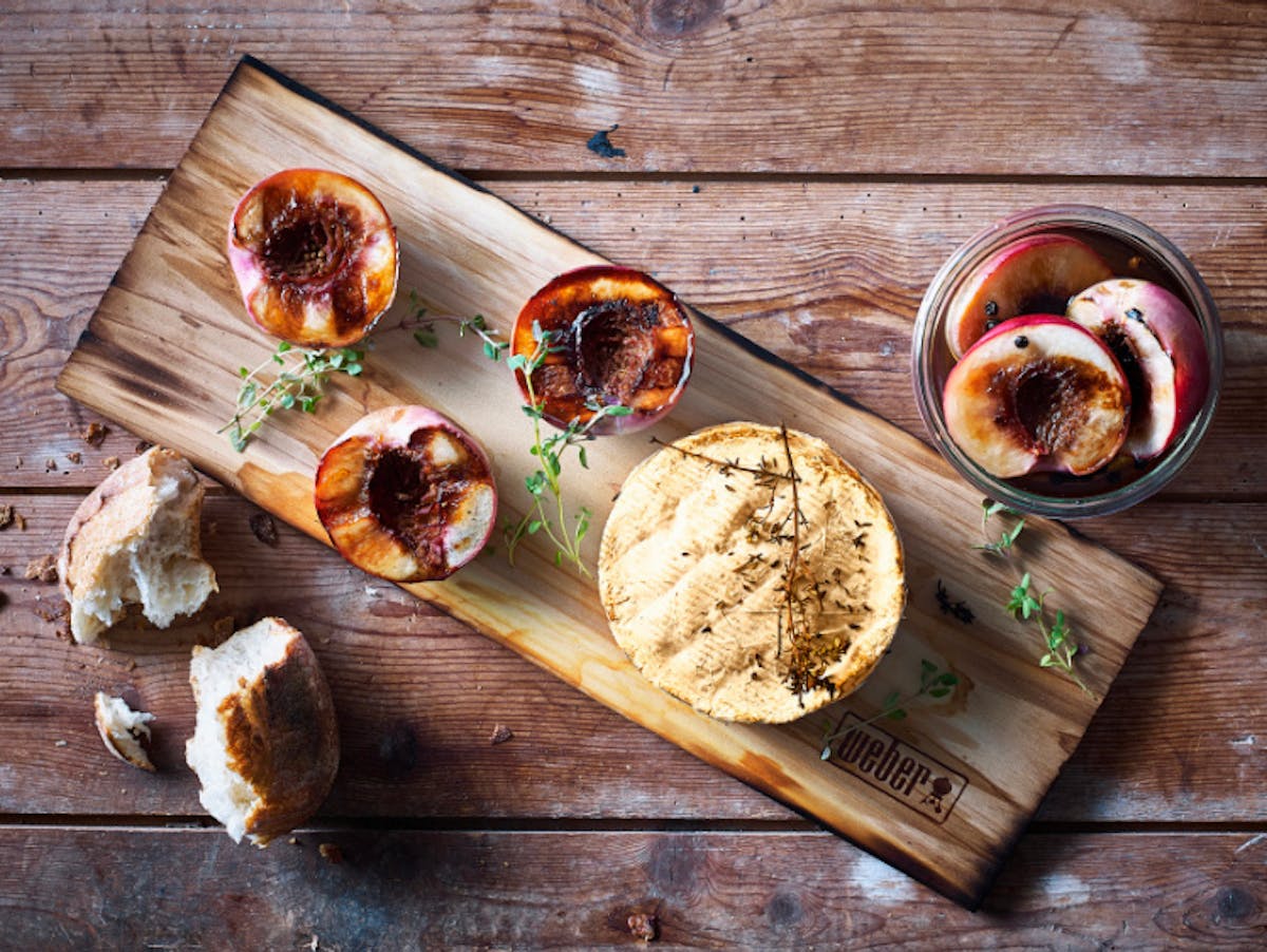 Geräucherter Camembert-Grillkäse auf einem Räucherbrett von Weber mit pfeffermarinierten Nektarinen
