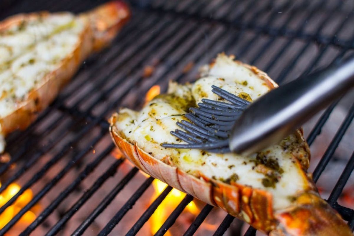 seasoning lobster tail on the grill