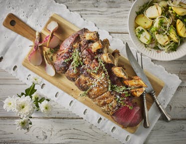 Côte à l'os met gegrilde aardappelsalade en gebakken uien