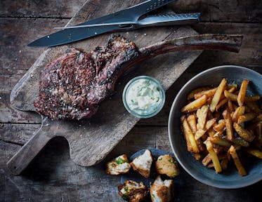 Tomahawk-biff med pommes frites, jalapeño-aioli och vitlöksbröd