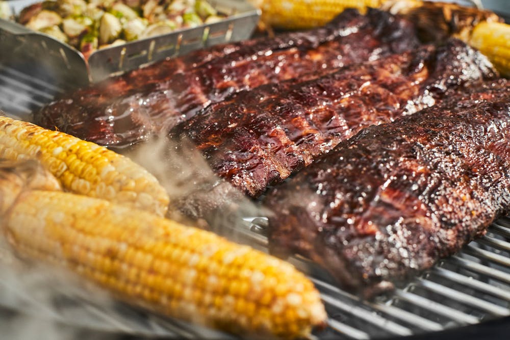 Saftige Spareribs mit Mais auf Grill mit weiterem Gemüse